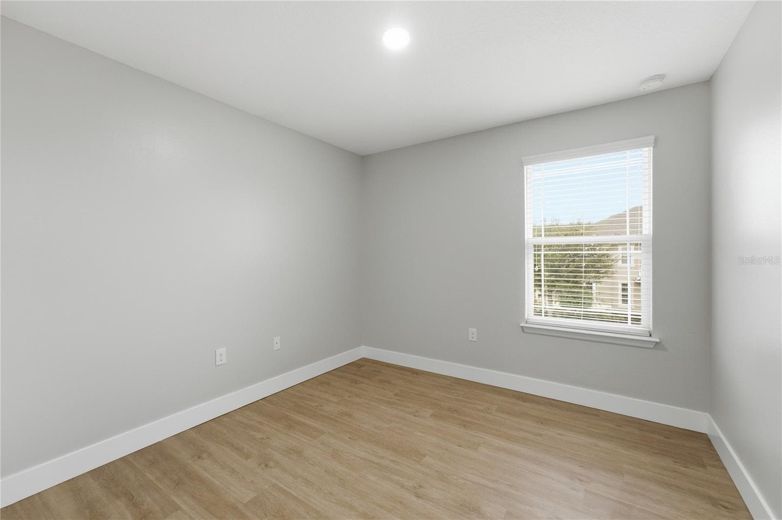 Bright second bedroom with vinyl plank flooring and a large window providing natural light. - 2615 GIARDINO LOOP, KISSIMMEE