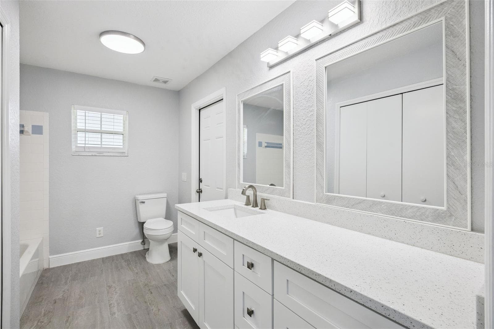 guest bath with large linen closet, tall vanity with Quartz top, tub and shower combination and direct access to the covered patio - 5606 LAVER ST, LEESBURG