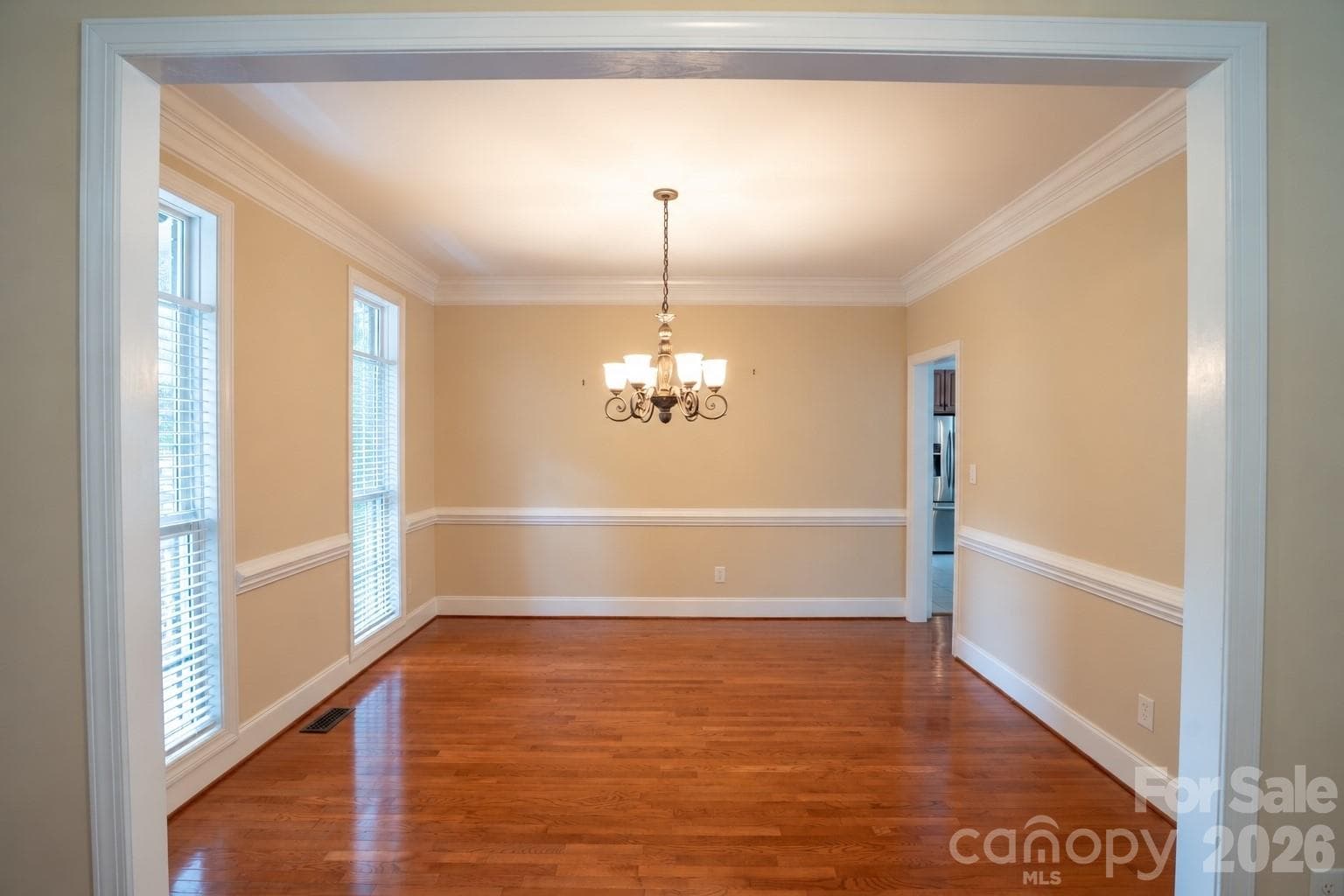 Dining room with floor to ceiling window, hard wood floors, and crown molding - 1927 Windmere Drive, Monroe
