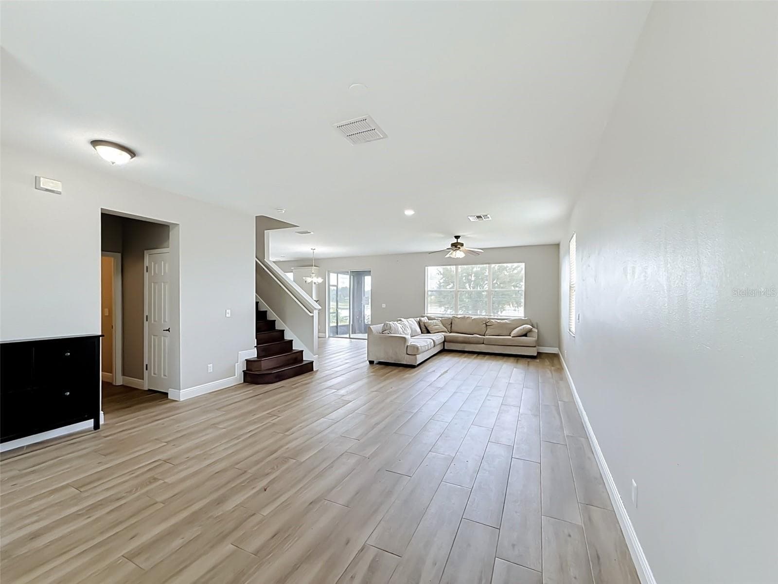 View from the entry through the open great room toward the lake - 852 N JACKS LAKE RD, CLERMONT