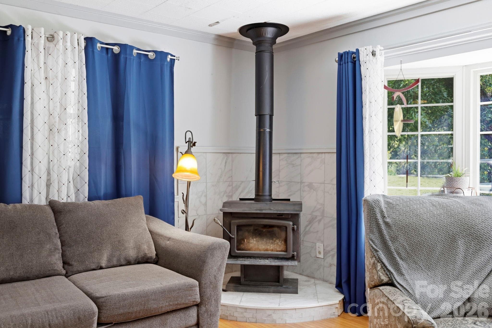 Living room from kitchen doorway, wood burning stove start of bay window - 10687 Cruso Road, Canton