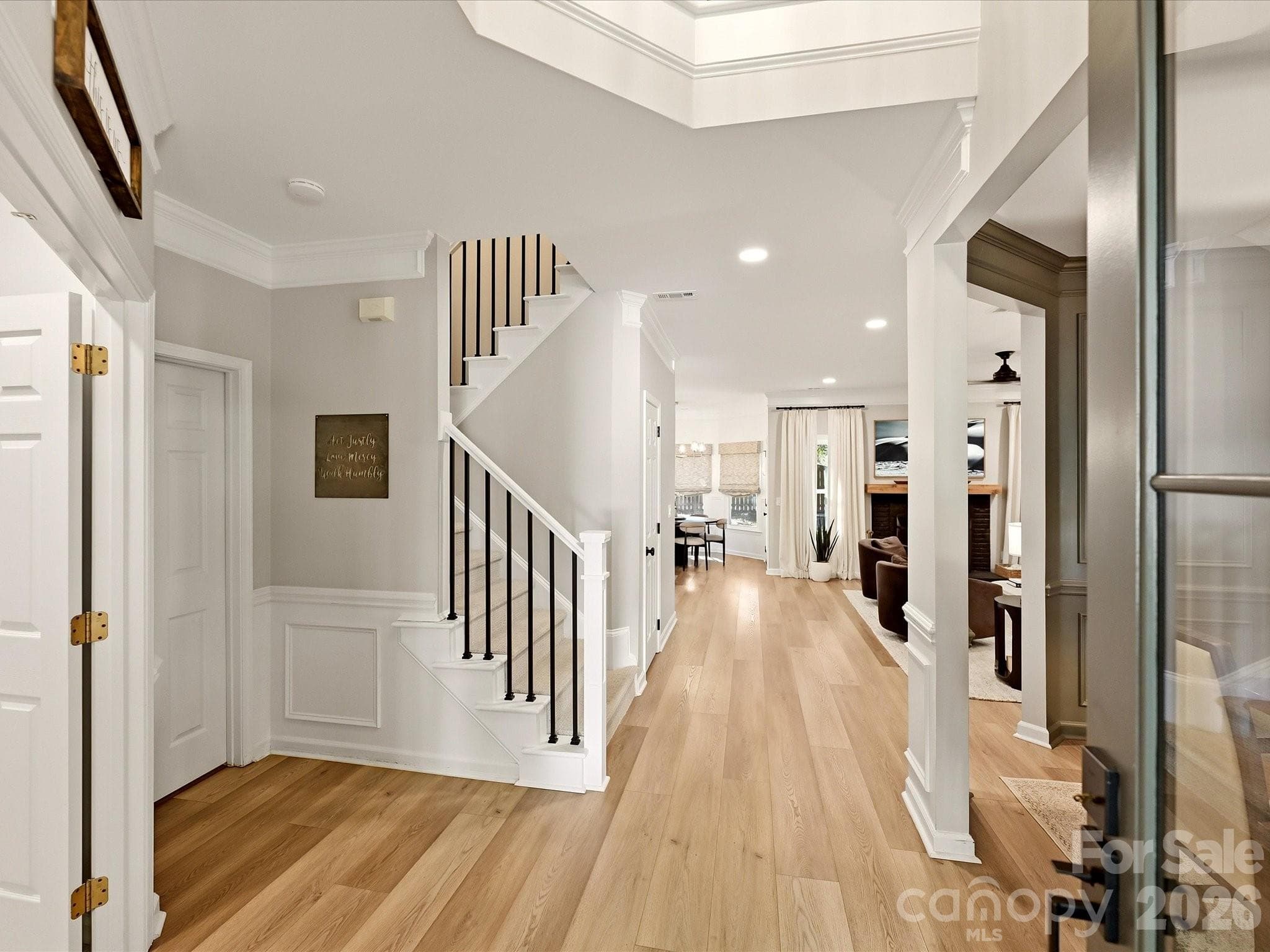Welcoming entry foyer features wood-look vinyl plank flooring, detailed trim, and an open layout leading into the home's main living spaces. - 19706 Valiant Way, Cornelius