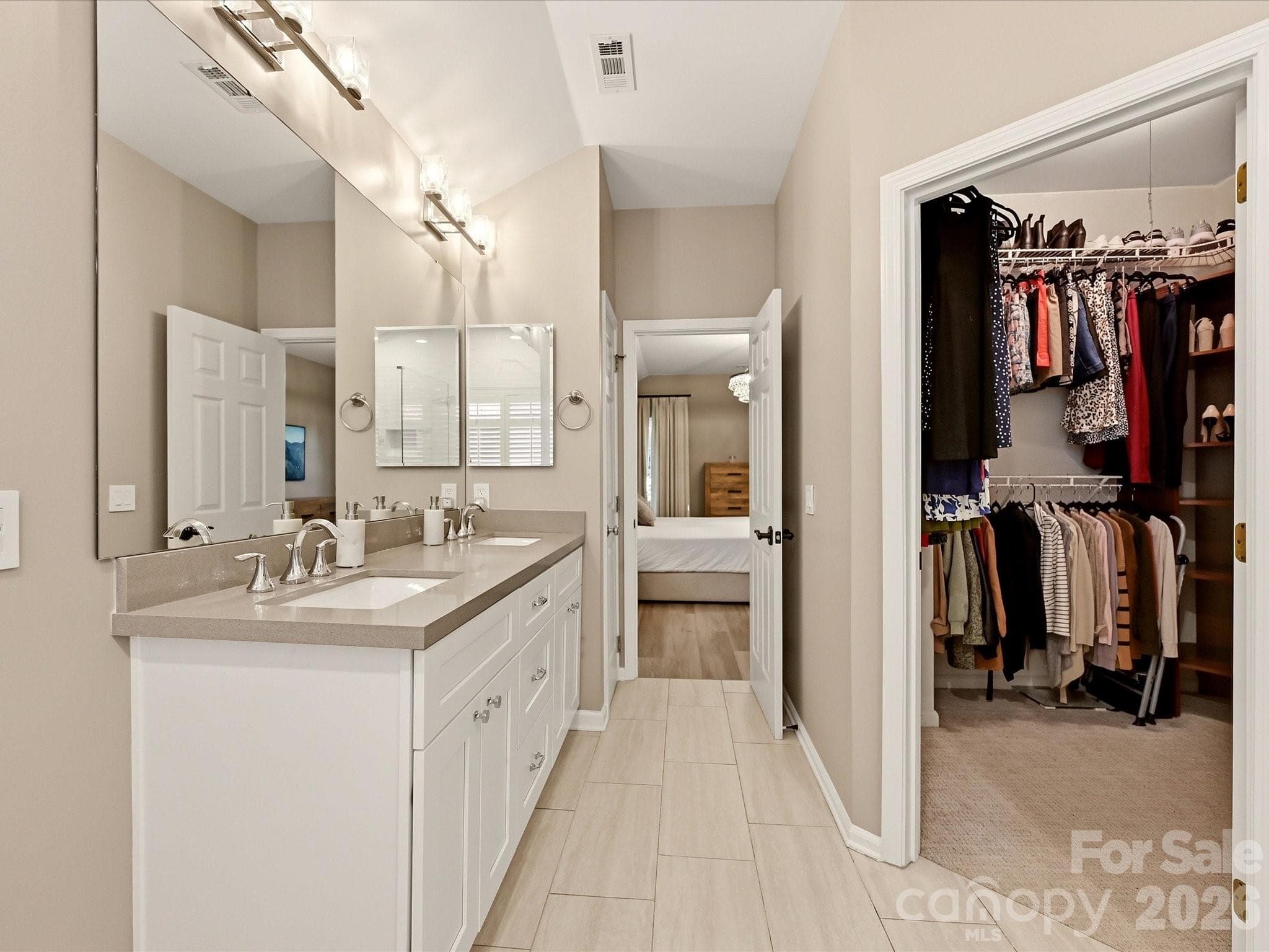 Additional primary bath view highlights the dual vanity, generous storage, and adjoining walk-in closet. - 19706 Valiant Way, Cornelius