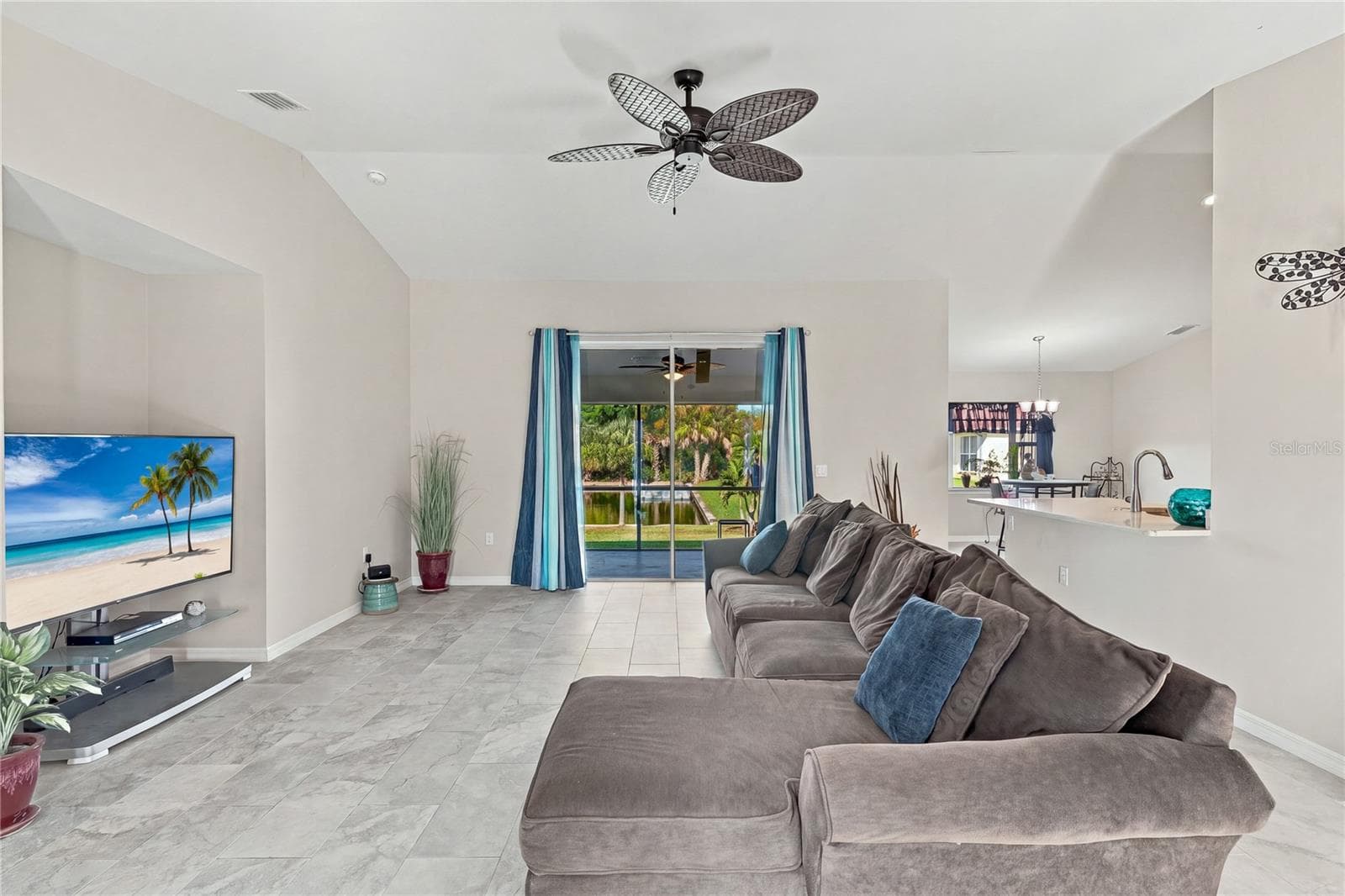 LIVING ROOM WITH VIEW OF LANAI AND WATER AND TILE THROUGHOUT. - 10554 LIVE OAK RD, PORT CHARLOTTE