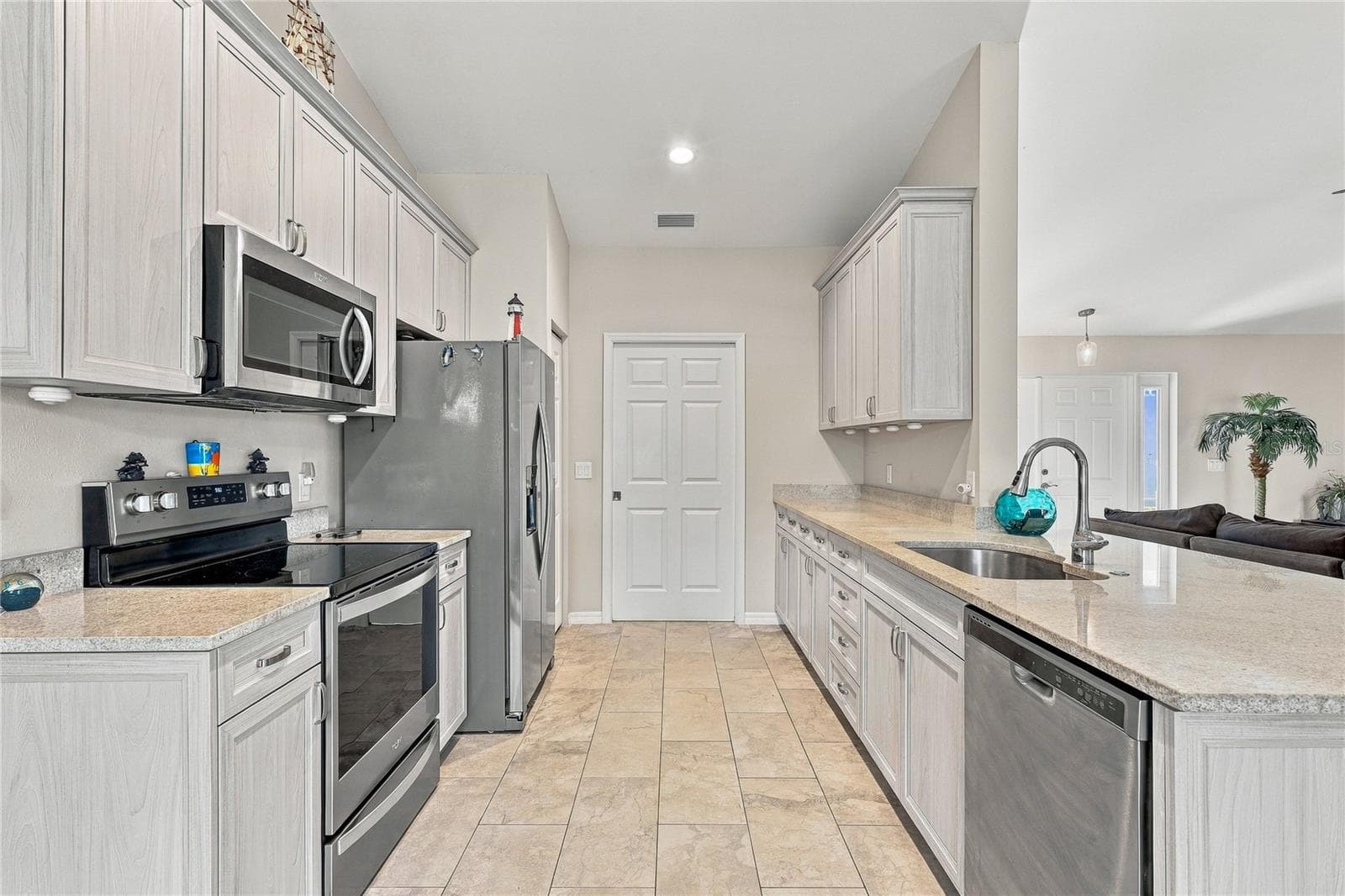 KITCHEN ALL APPLIANCES STAY AND POCKET DOOR TO INDOOR LAUNDRY AND GARAGE - 10554 LIVE OAK RD, PORT CHARLOTTE