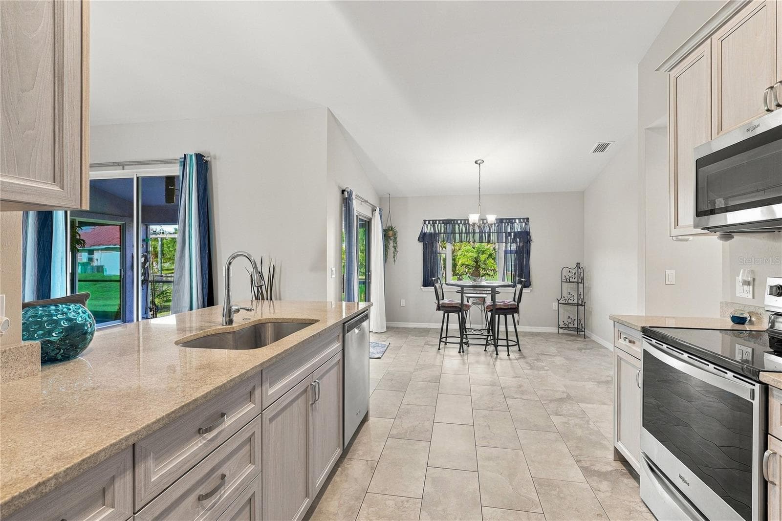 KITCHEN LIGHT AND BRIGHT WITH STONE COUNTERS, TILE THROUGHOUT AND STAINLESS STEAL APPLIANCES - 10554 LIVE OAK RD, PORT CHARLOTTE