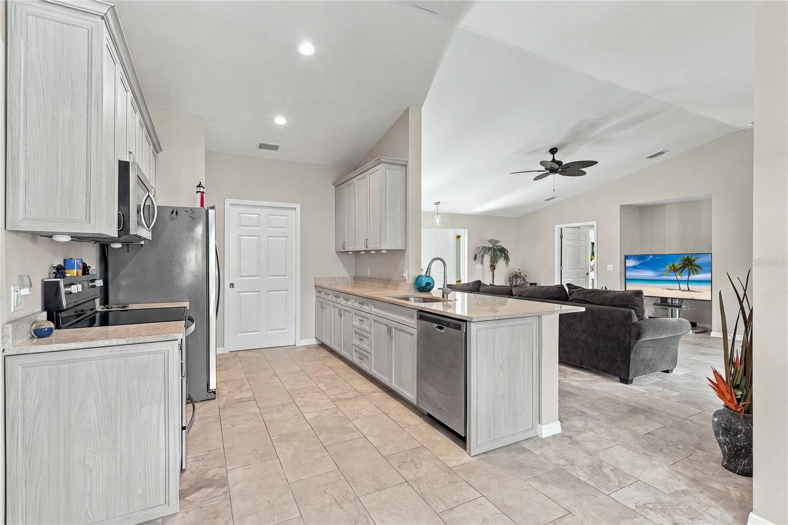 KITCHEN VIEW OF UPGRADED CABINETS AND GRANITE COUNTERS OVERLOOKING LIVING AREA - 10554 LIVE OAK RD, PORT CHARLOTTE
