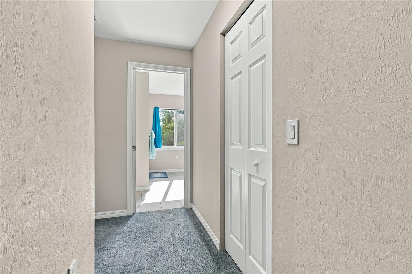 HALL FROM PRIMARY BEDROOM TO OVERSIZED WALK IN CLOSET AND BATH - 10554 LIVE OAK RD, PORT CHARLOTTE
