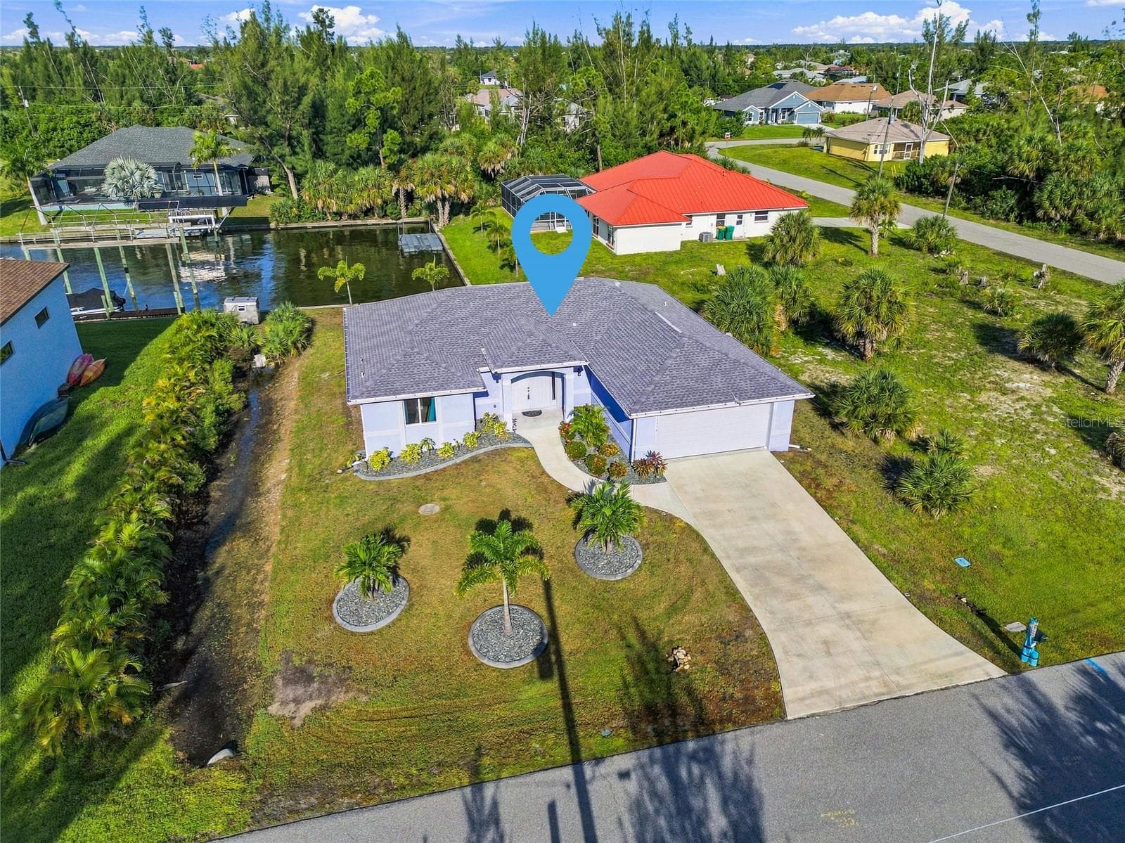 AIREAL OF HOUSE ON CANAL WITH SEAWALL AND LUSH FLORIDA LANDSCAPING - 10554 LIVE OAK RD, PORT CHARLOTTE