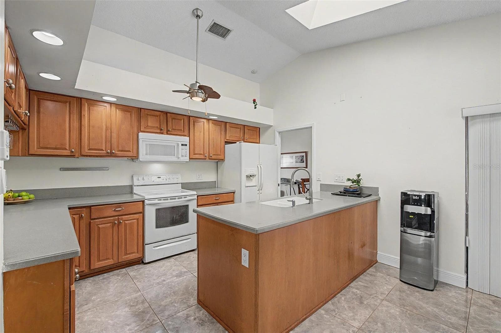 Kitchen with 2 skylights and eating area with 2 slider doors to the pool area. - 8612 BRAXTON DR, HUDSON