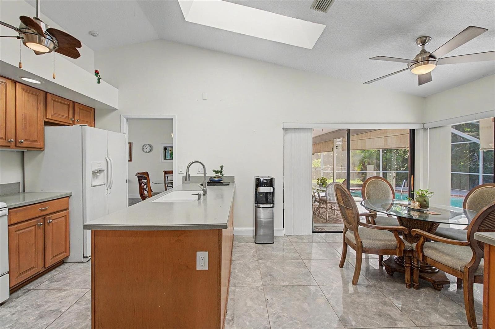 Kitchen with 2 skylights and eating area with 2 slider doors to the pool area. - 8612 BRAXTON DR, HUDSON