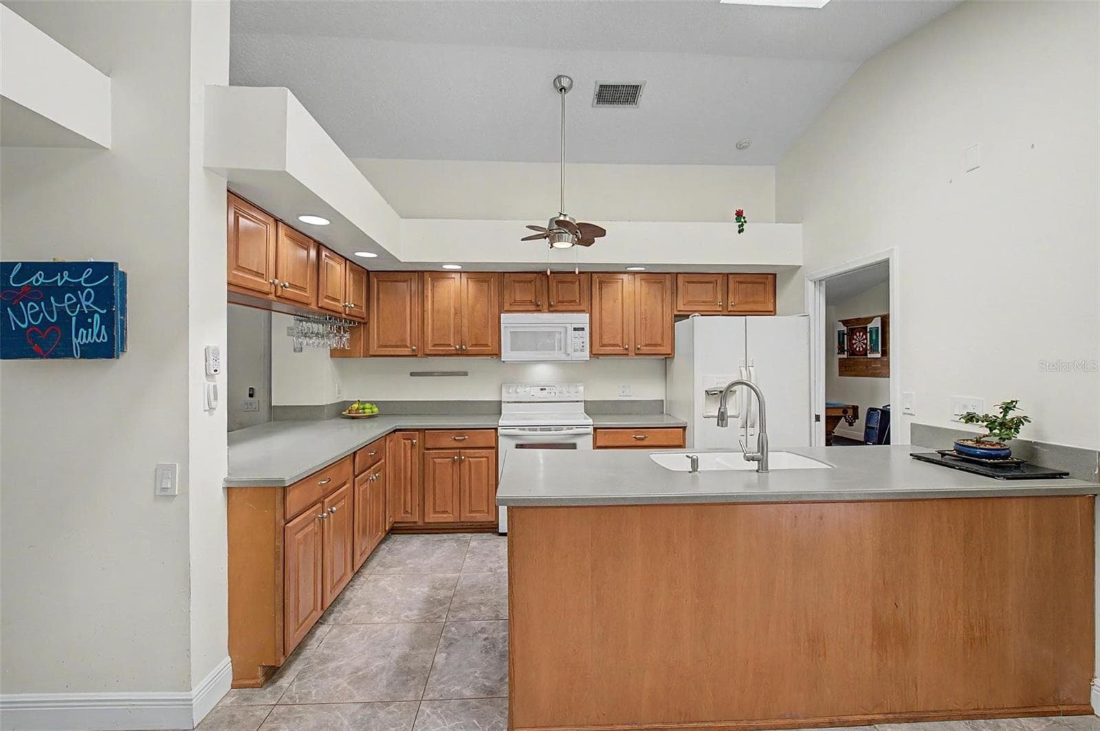 Kitchen with 2 skylights and eating area with 2 slider doors to the pool area. - 8612 BRAXTON DR, HUDSON