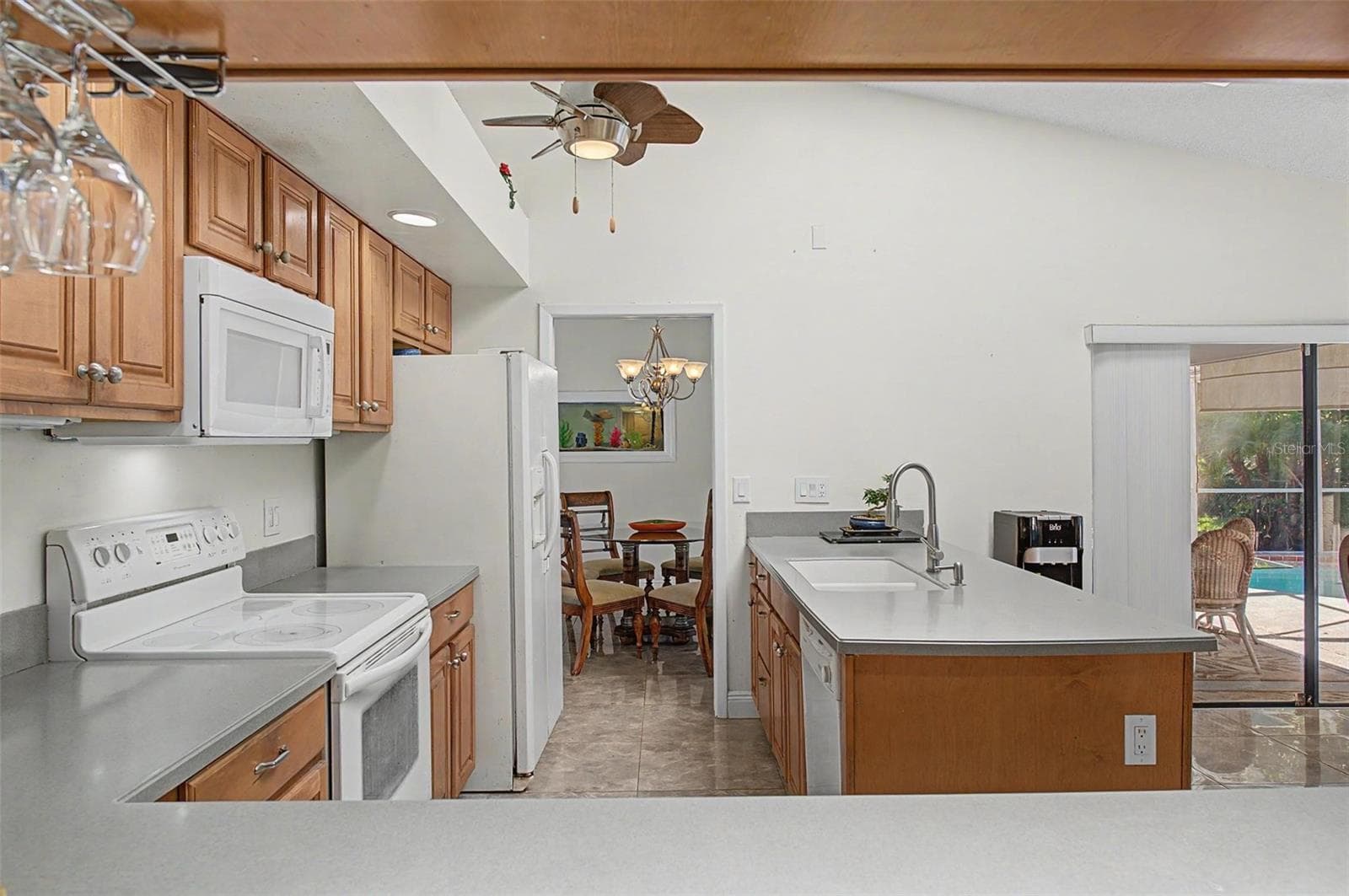 Kitchen with 2 skylights and eating area with 2 slider doors to the pool area. - 8612 BRAXTON DR, HUDSON