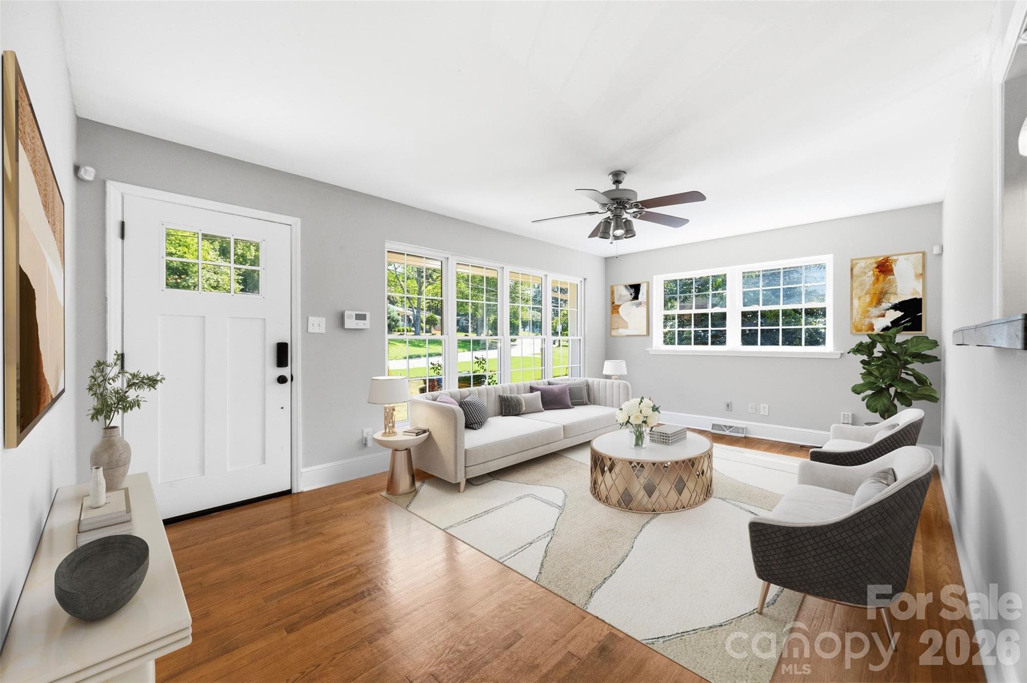 Fresh paint throughout the home accented with gorgeous oak hardwood floors. This view is the front living room looking outside to the front yard. Craftsman style front door, built in security system conveys. New owner to establish monitoring. - 6506 Candlewood Drive, Charlotte