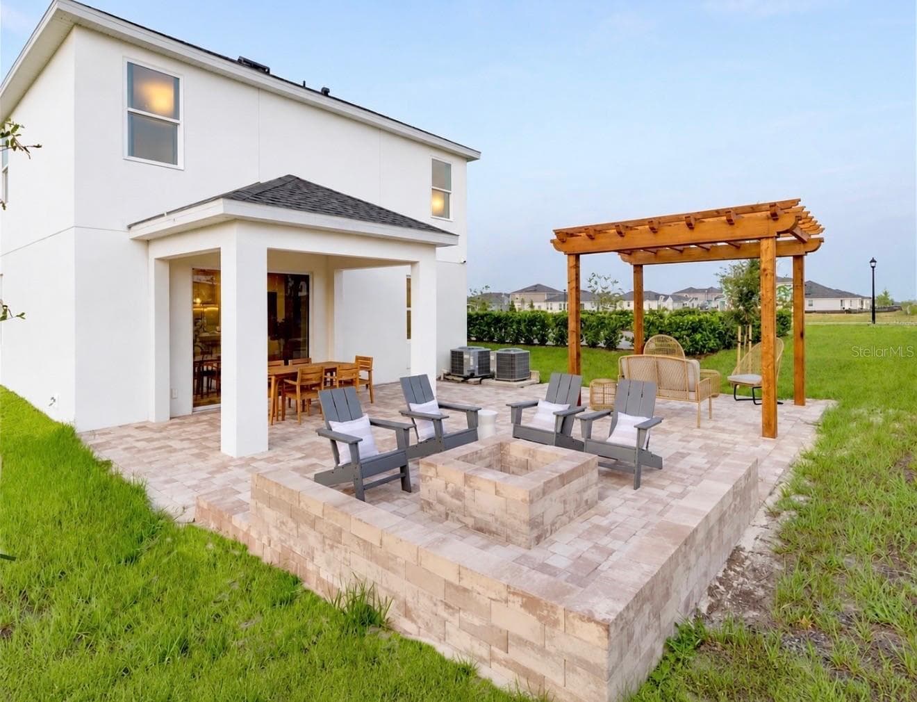 Backyard with extended paver patio, pergola, and outdoor living space. - 7104 DILLY LAKE AVE, GROVELAND