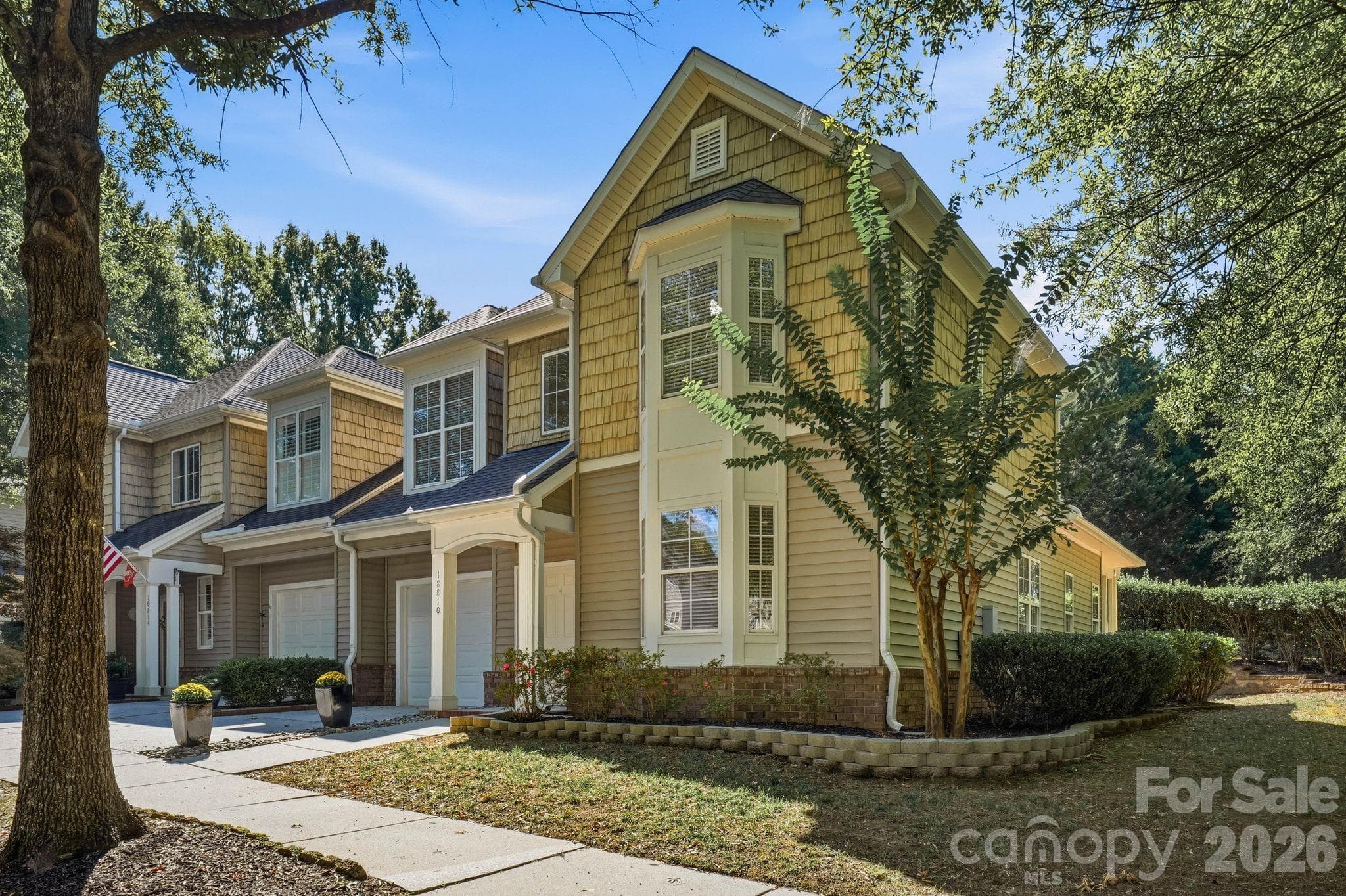 Charming side view of the end-unit exterior framed by mature landscaping and an established neighborhood setting. - 18810 Cloverstone Circle, Cornelius