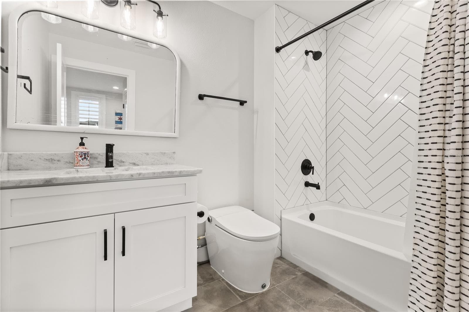 GUEST HOUSE FULL BATHThe carriage house apartment includes a full bath with tub-and-shower combination and herringbone tile surround. - 907 CELADON ST, WINTER GARDEN