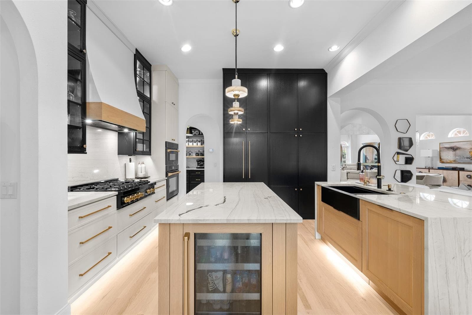 Island with built-in wine refrigerator, black pantry cabinetry, and glass-front uppers with pendant lighting. - 1921 FLORESTA VIEW DR, TAMPA