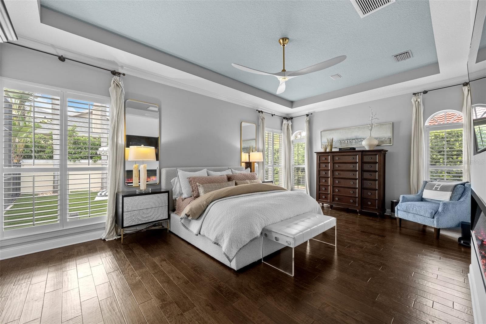Tray ceiling with ceiling fan, dark wood flooring, and plantation shutters on multiple windows. - 1921 FLORESTA VIEW DR, TAMPA