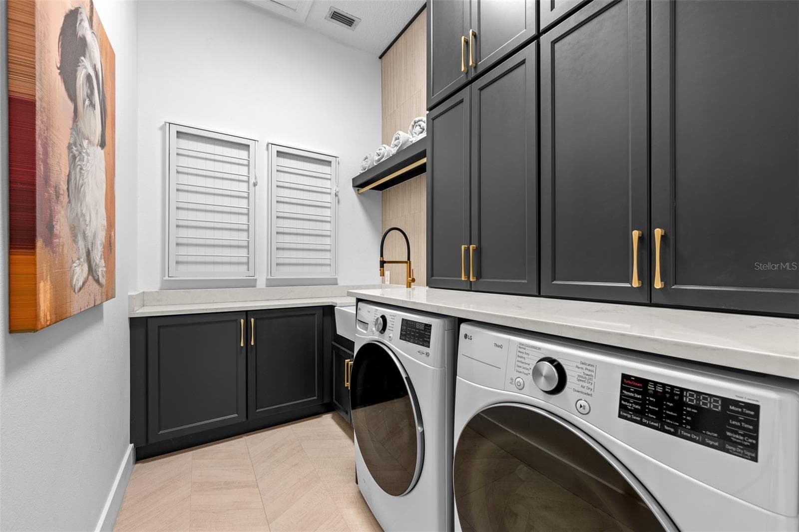 Laundry Room - Black shaker cabinets with brass pulls, front-load washer and dryer, and built-in louvered storage cabinets. - 1921 FLORESTA VIEW DR, TAMPA