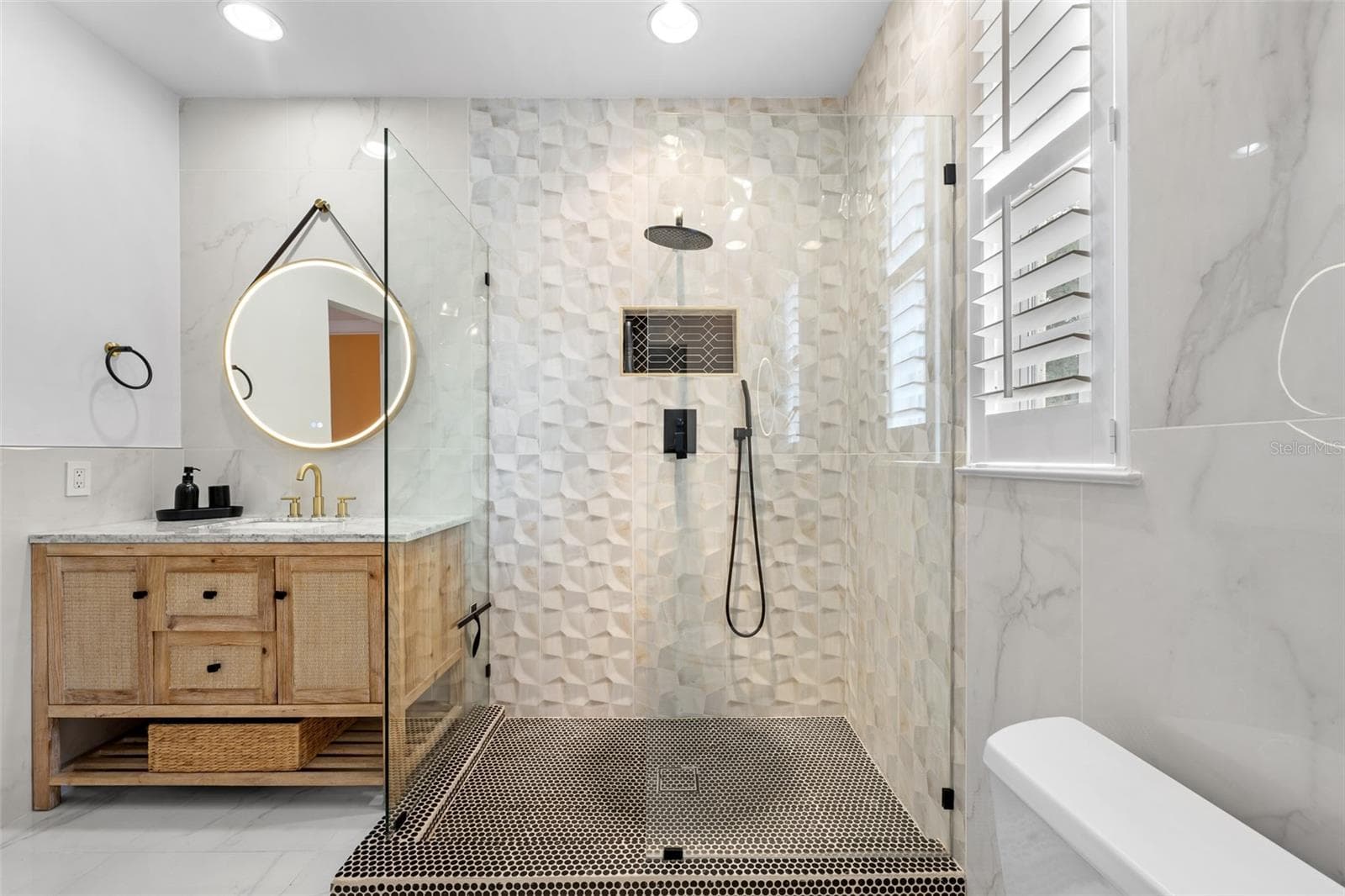 Second Bathroom (upstairs) - Glass-enclosed shower with three-dimensional tile, wall niche, and window with plantation shutters. - 1921 FLORESTA VIEW DR, TAMPA
