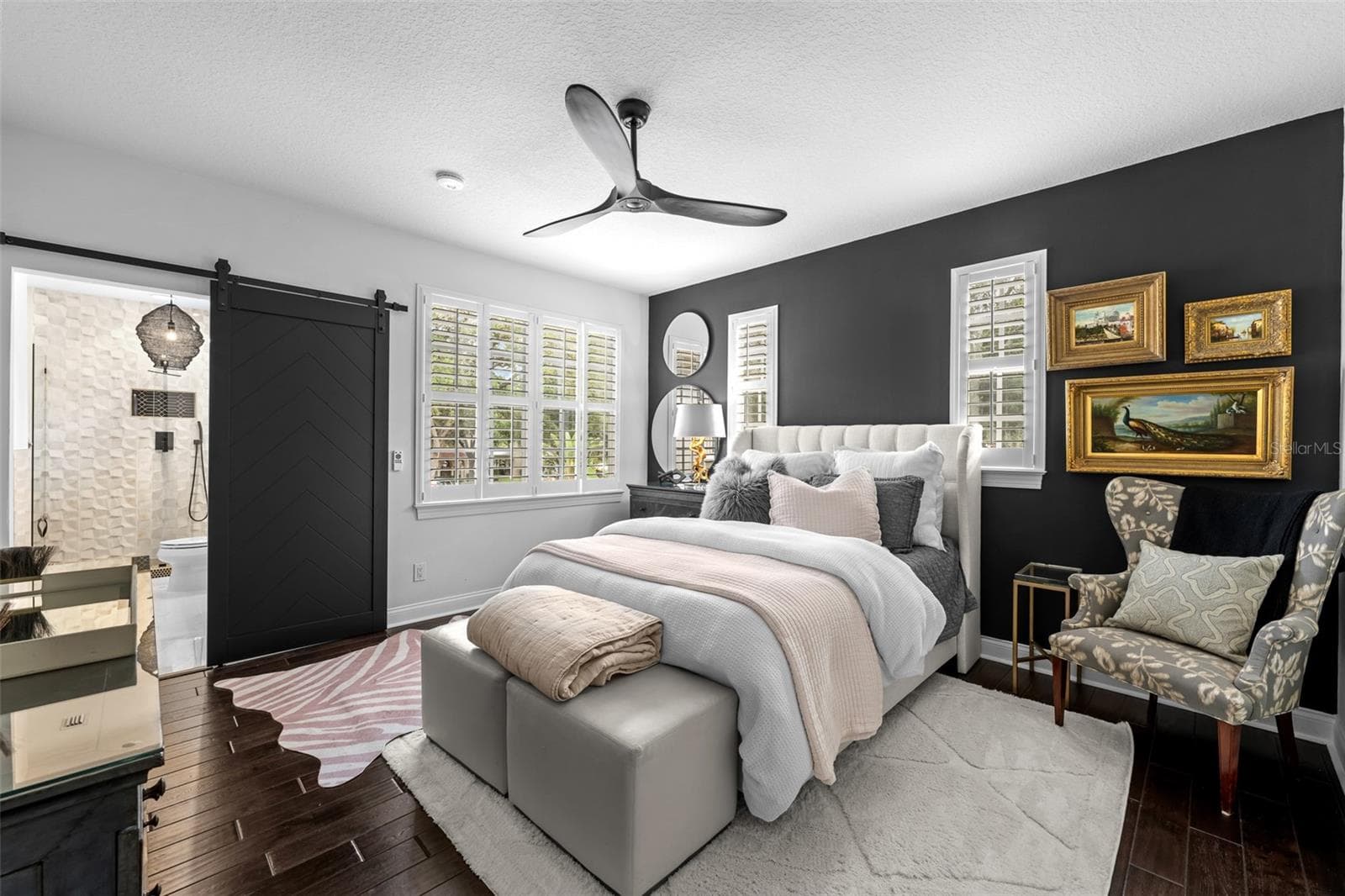 2nd Bedroom with dark accent wall, sliding barn door, ceiling fan, and plantation shutters. - 1921 FLORESTA VIEW DR, TAMPA