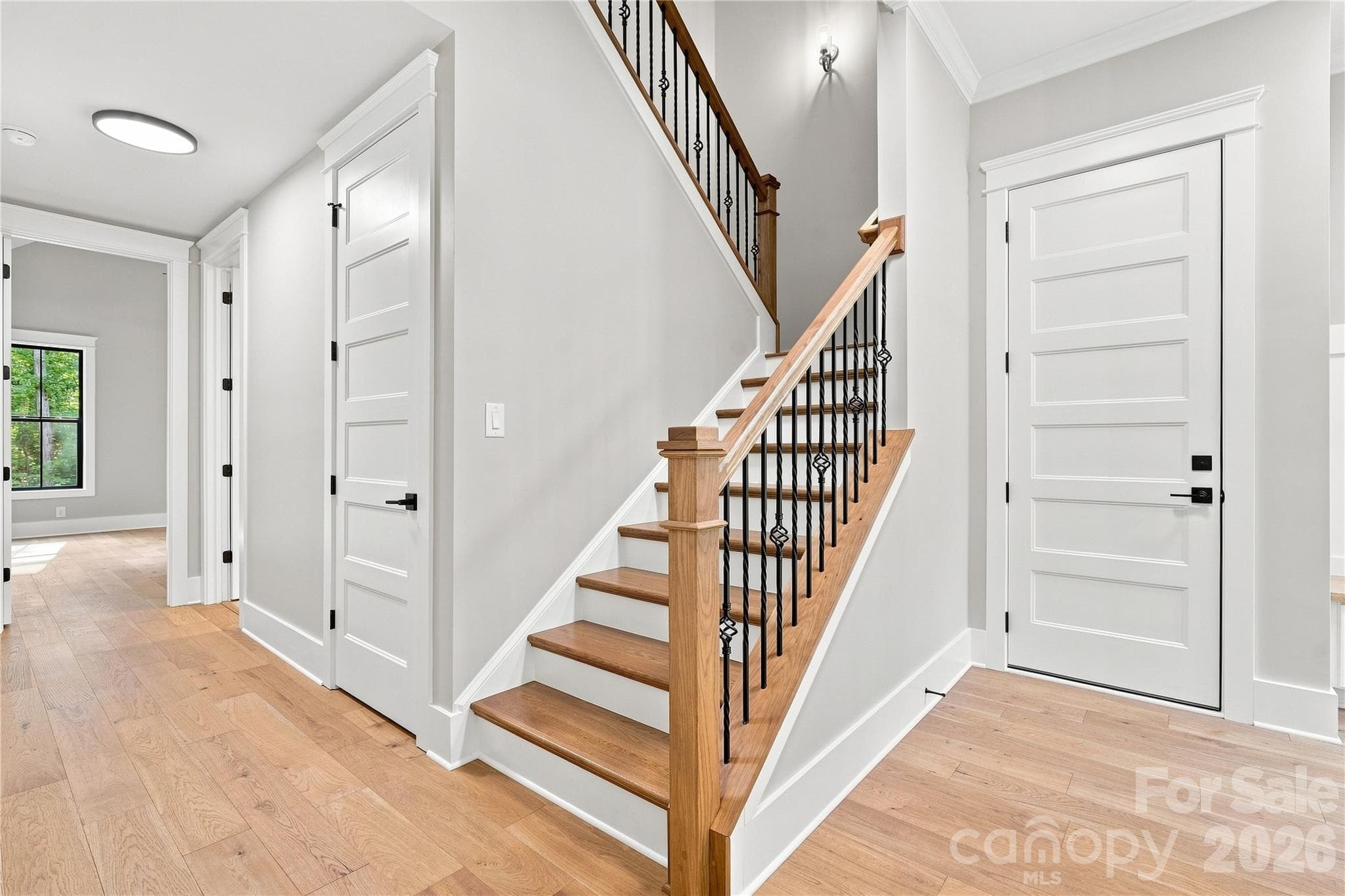 Hallway to stairs, garage, laundry room, linen closet, and primary bedroom. - 3515 Capricorn Road, Lancaster