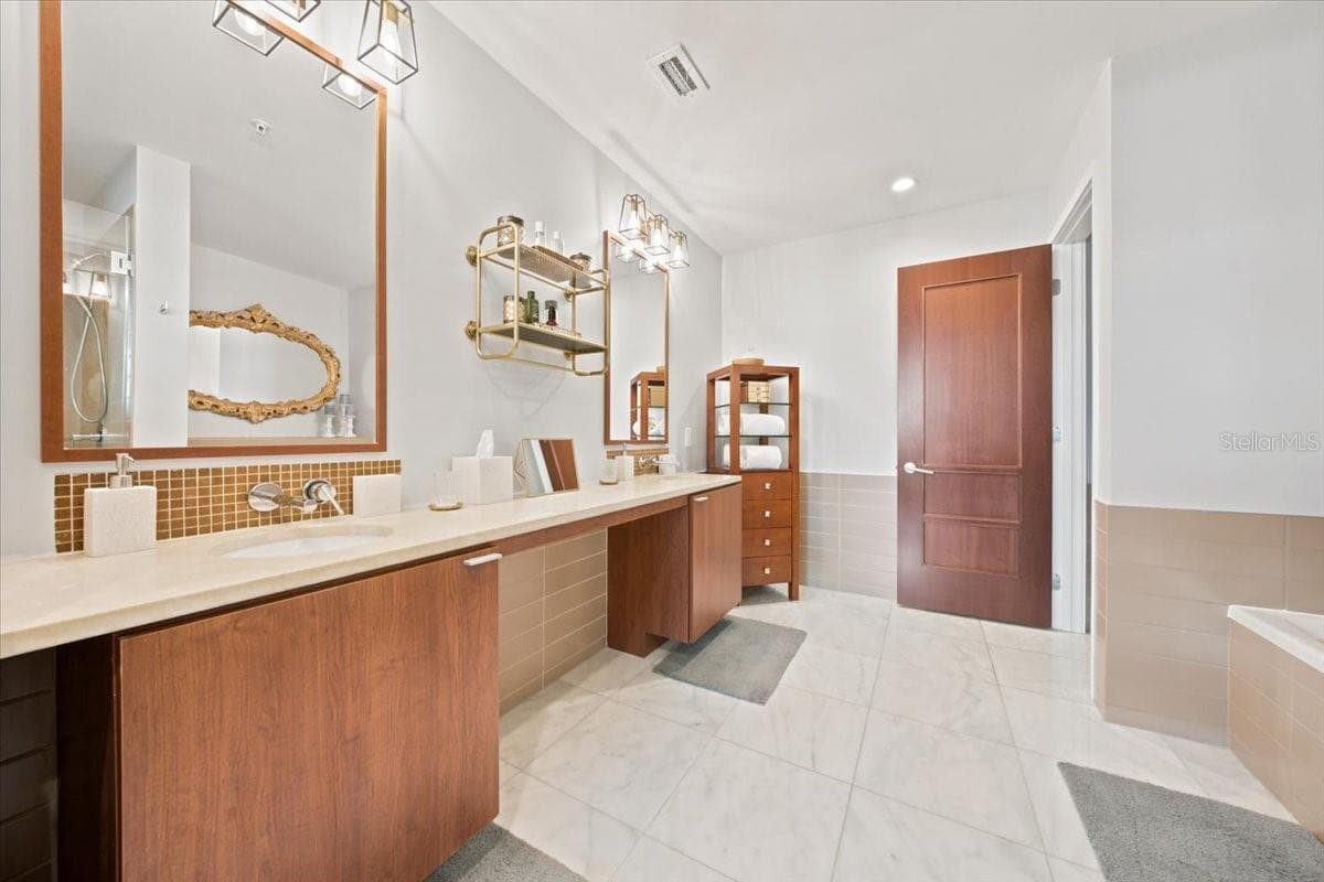 Beautifully remodeled primary bathroom showcases sophisticated marble finishes. - 111 N 12TH ST #1704, TAMPA
