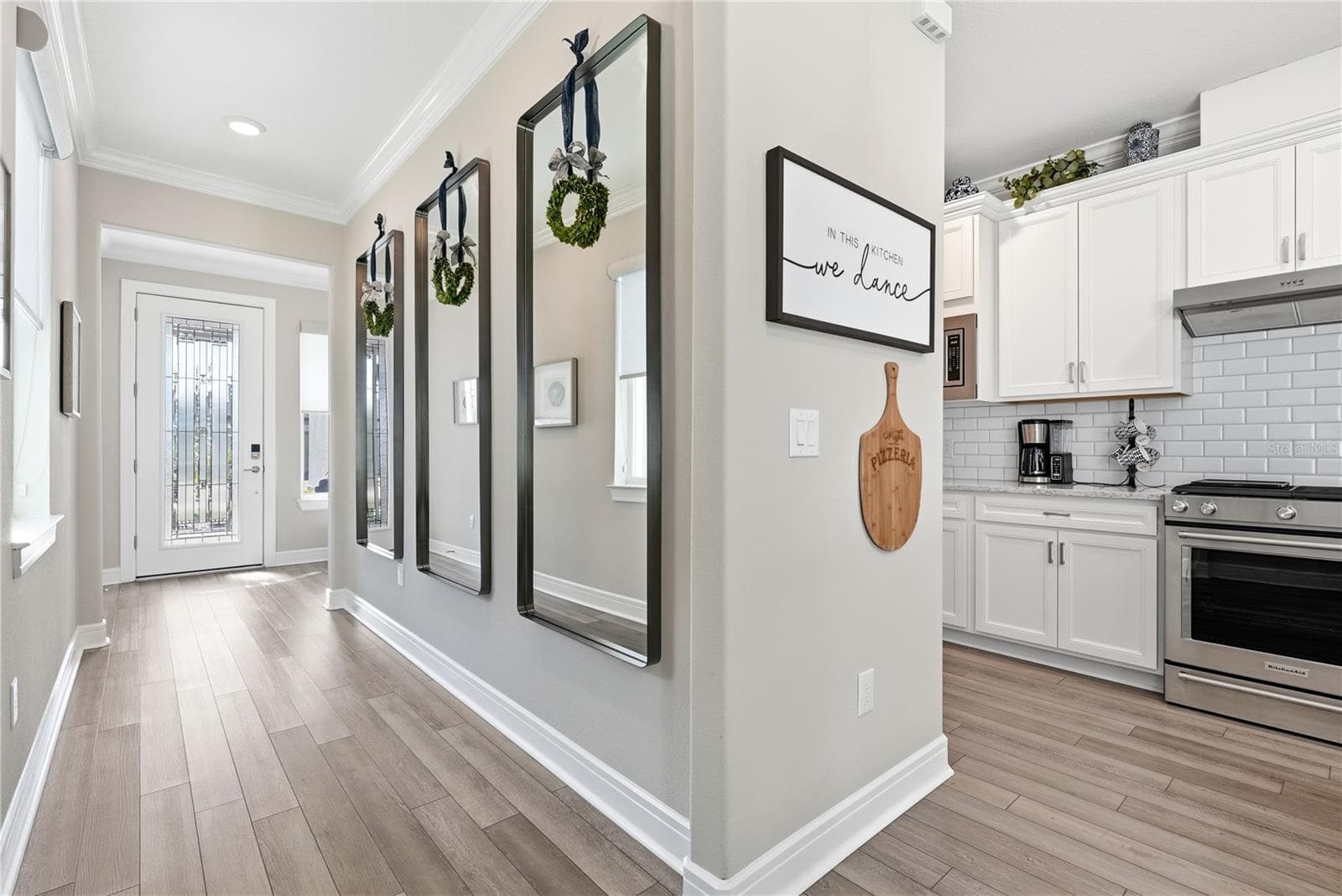 View from the kitchen to the entrance. The glass front door provides plenty of light. - 5535 BLUE CRUSH BND, LAND O LAKES