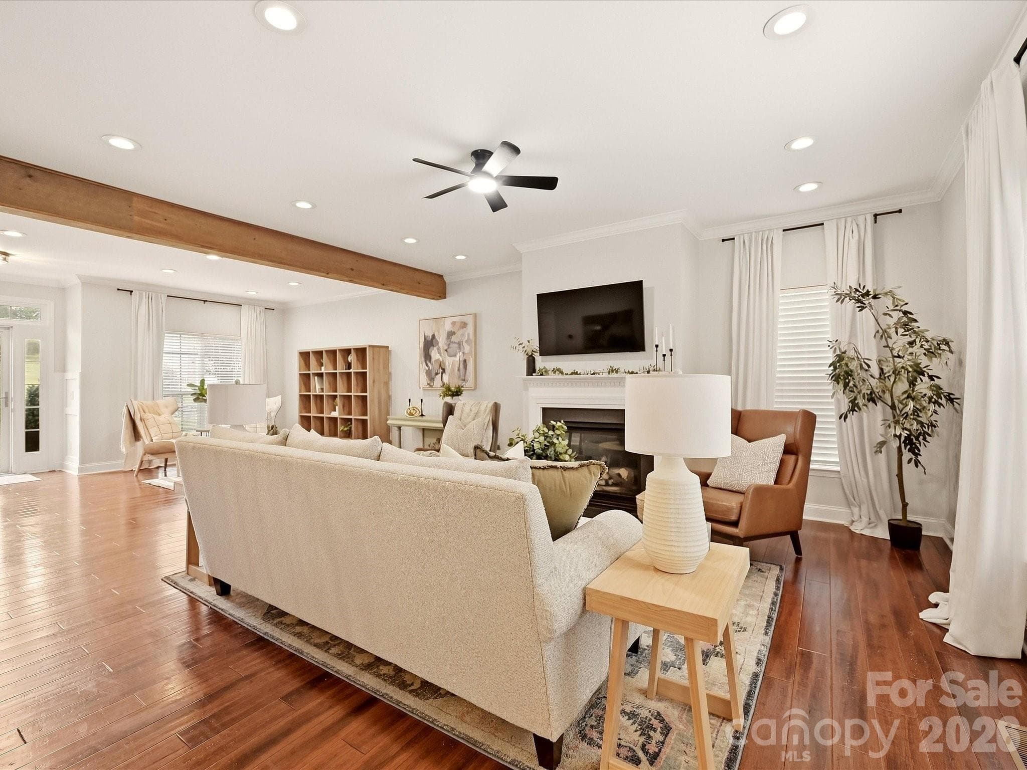 The inviting Great Room features a cozy fireplace, rich wood floors, abundant natural light, and plenty of space for comfortable everyday living. - 16006 Lavenham Road, Huntersville