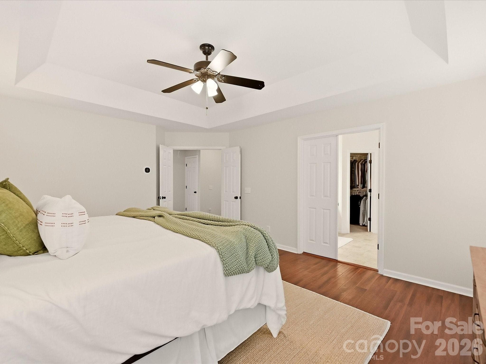 The spacious primary suite features wood floors, a tray ceiling, abundant natural light, and a generous walk-in closet for added comfort and convenience. - 16006 Lavenham Road, Huntersville