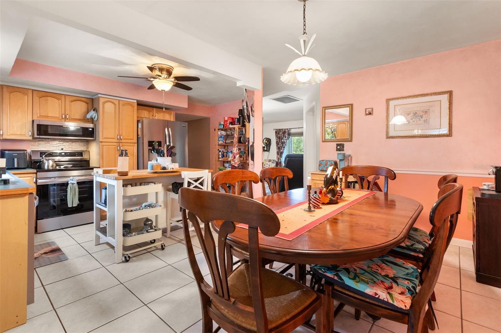 Dining room and kitchen are open to one another. Far doorway to right is to living room, far doorway to the left is to bedroom hallway. One bonus room is behind photographer. - 4511 LONGWORTH DR, ORLANDO