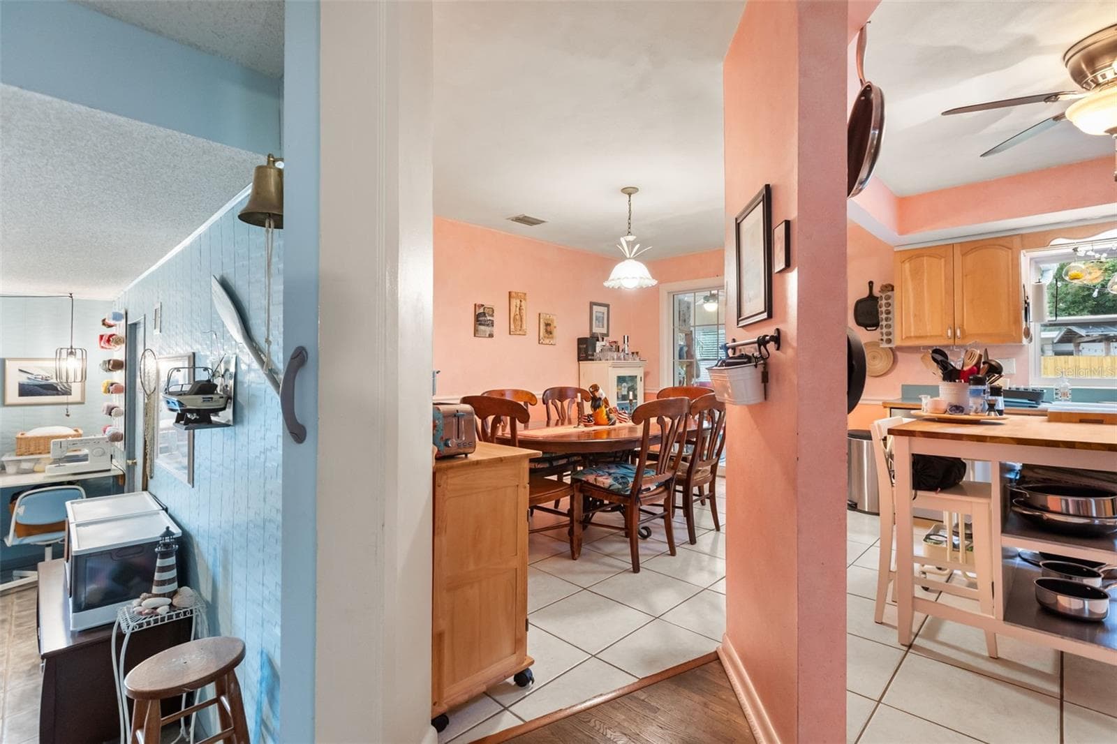 Bonus room, dining room, and kitchen. Off to the right is the hallway to the downstairs bedrooms. Behind photographer is the downstairs living room. - 4511 LONGWORTH DR, ORLANDO