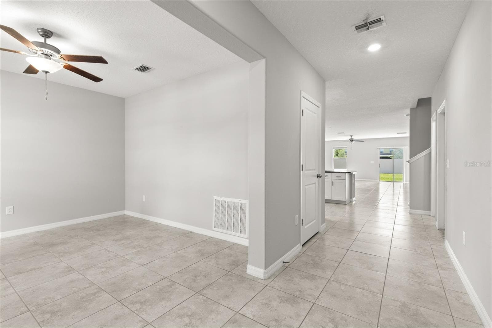 From the foyer, the main level opens toward the kitchen, great room and backyard, while the bonus room/office sits just off the entry and provides flexible fifth-bedroom space. Continuous tile and fresh neutral finishes keep the main level feeling open and connected. - 5061 WHITE CHICORY DR, APOLLO BEACH