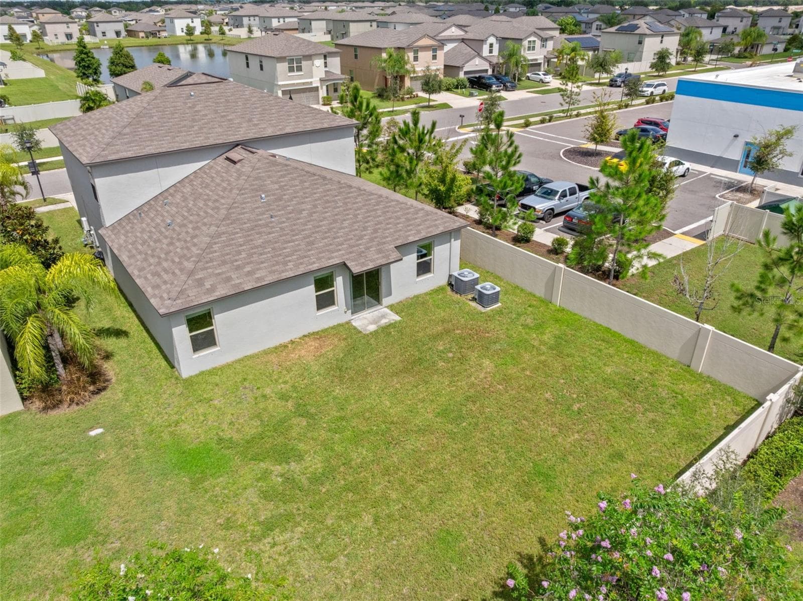 The aerial view makes the backyard’s size especially clear, with a broad, open lawn, privacy fencing and plenty of room to add a future pool, patio or other outdoor living features. - 5061 WHITE CHICORY DR, APOLLO BEACH