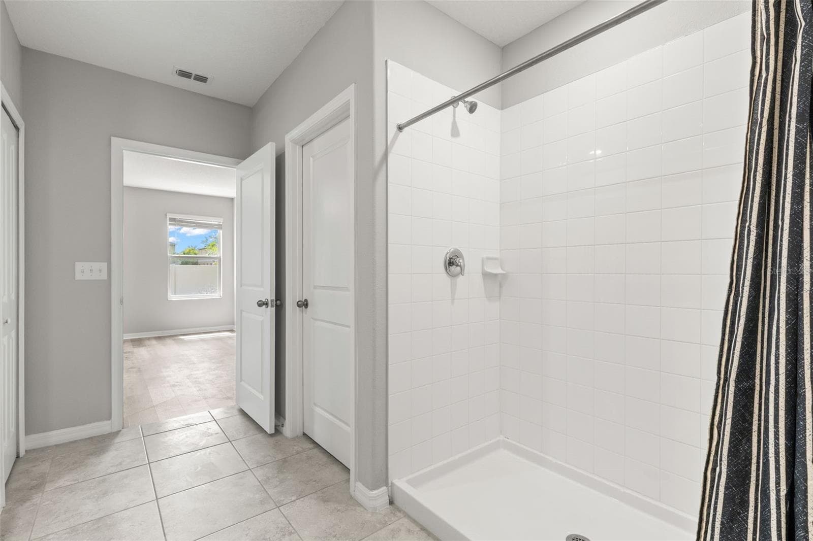 The primary ensuite includes a spacious tiled shower, complementing the dual-sink granite vanity and generous storage. - 5061 WHITE CHICORY DR, APOLLO BEACH