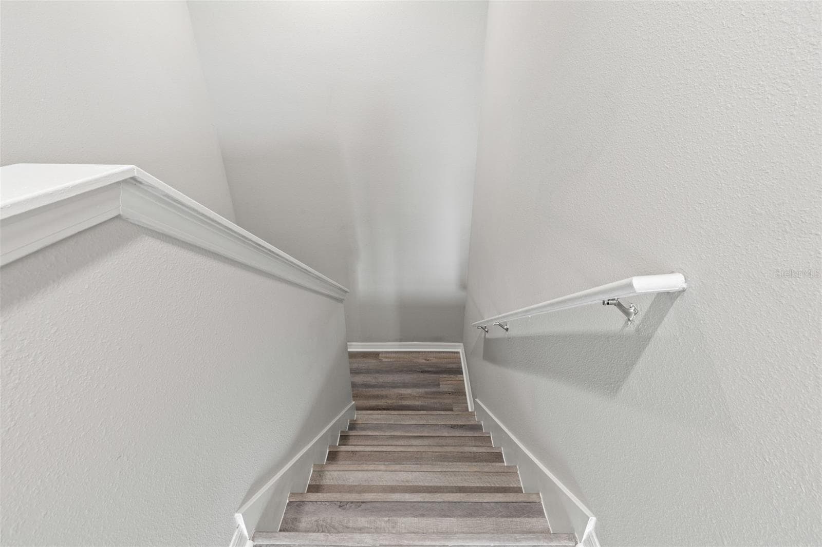 Newly replaced laminate flooring continues up the staircase to the second level, home to the secondary bedrooms and a spacious loft. - 5061 WHITE CHICORY DR, APOLLO BEACH