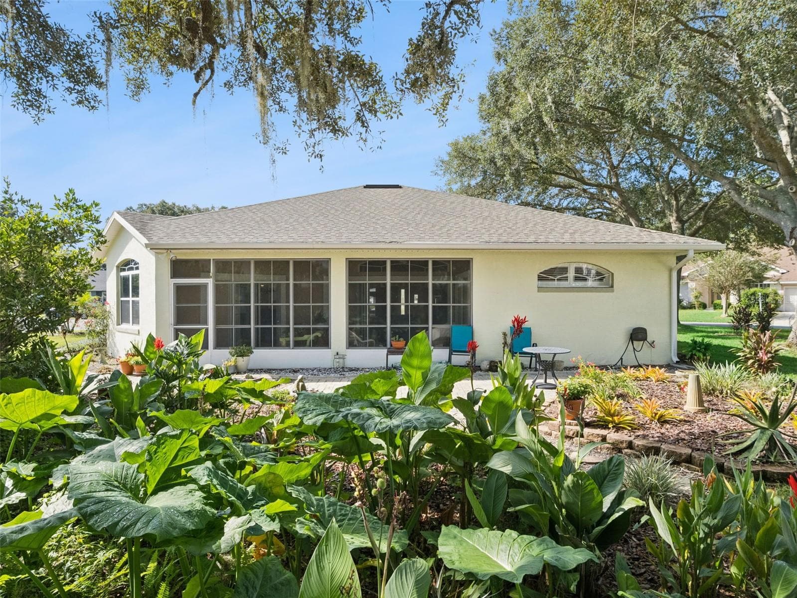The backyard is adorned with Florida-friendly plantings and a lovely garden walk, plus a spacious patio to sit and enjoy the view. - 5401 ESSEX CT, LEESBURG