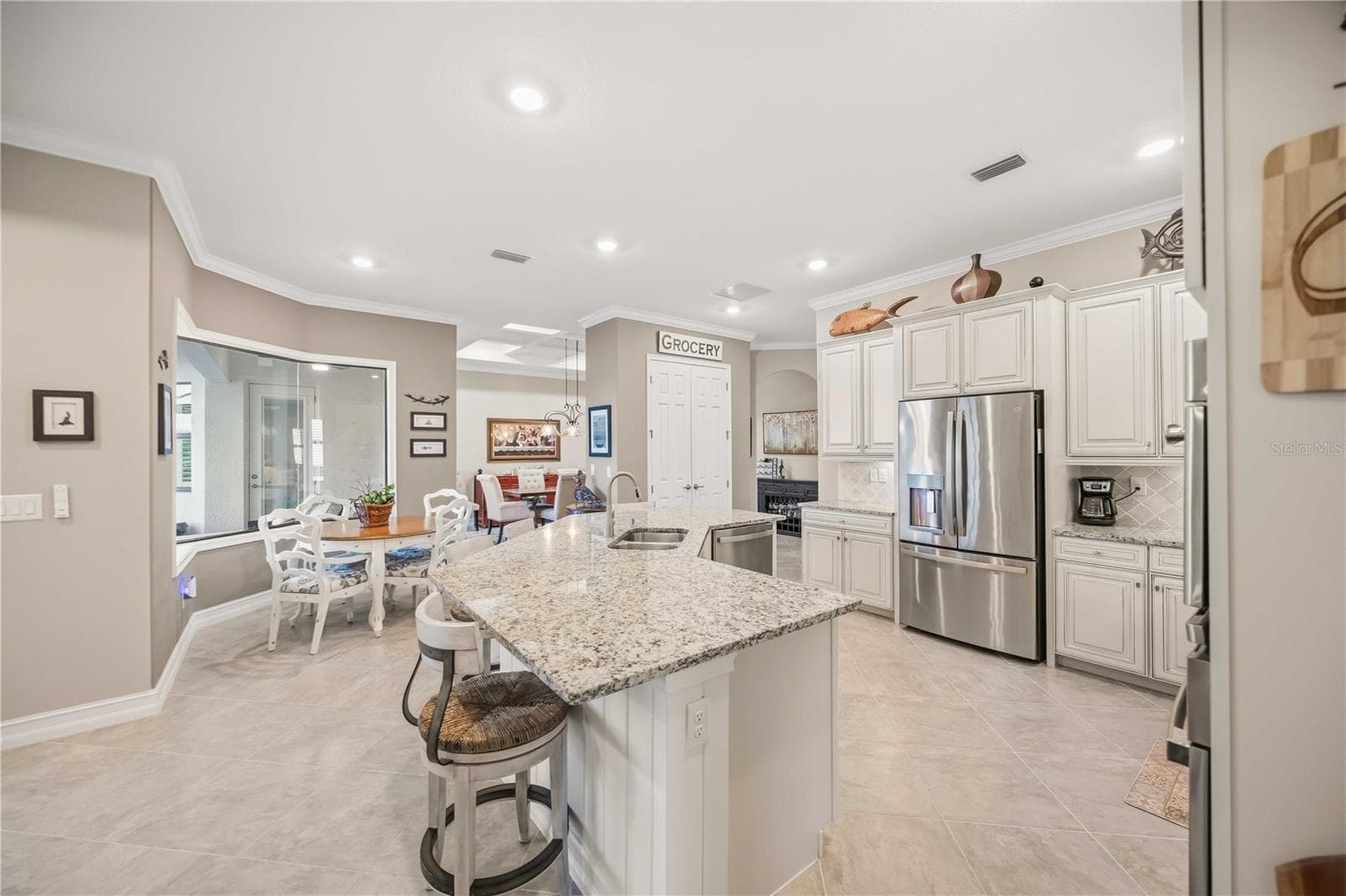 Upscale Kitchen with double ovens, dishwasher, cooktop, plenty of counter space, and counter seating. - 10720 TARFLOWER DR, VENICE