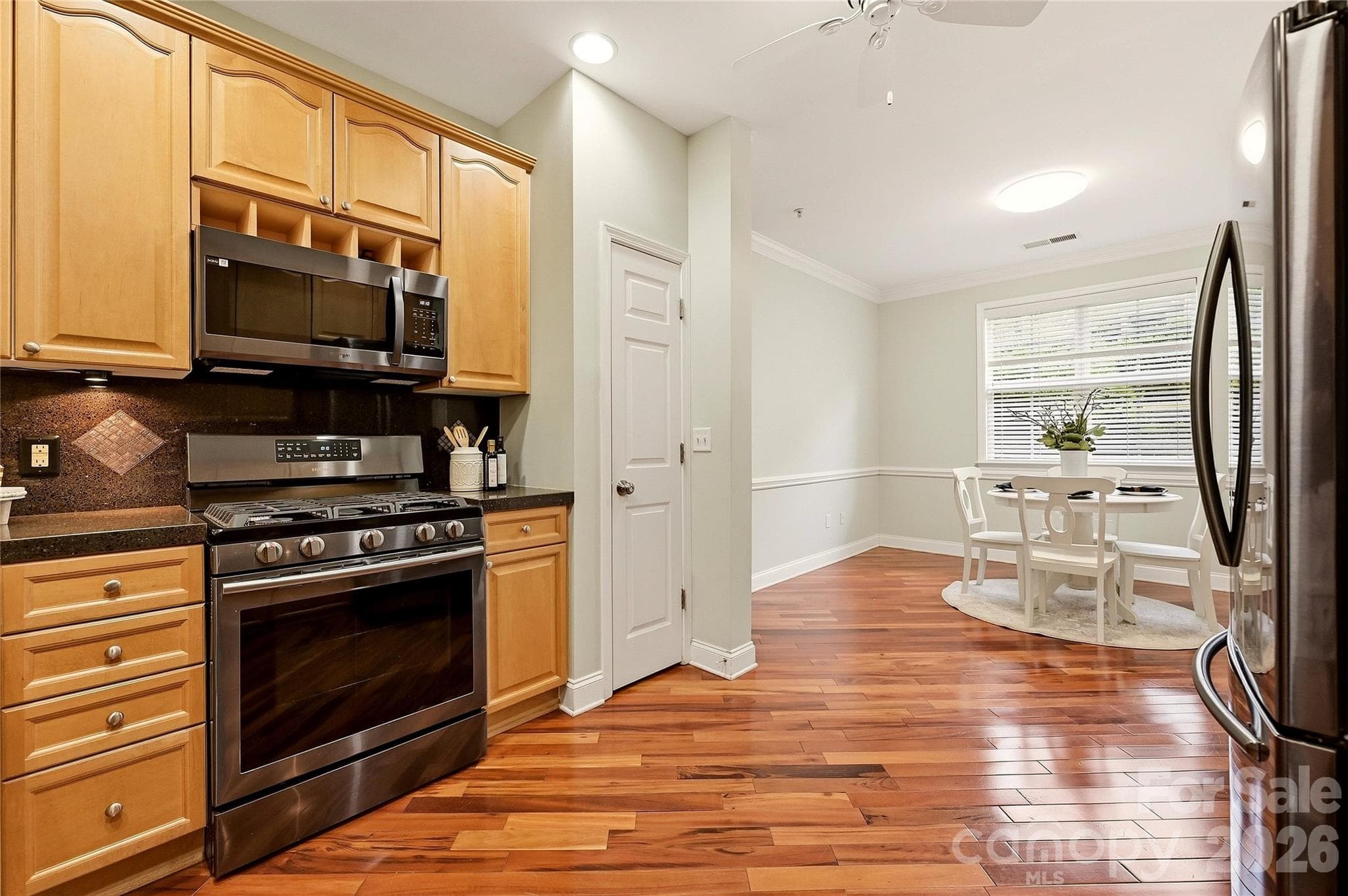 Additional kitchen view showcases extensive cabinetry, counter space, gas cooking, and the refrigerator that conveys with the home. - 9009 Rosalyn Glen Road, Cornelius