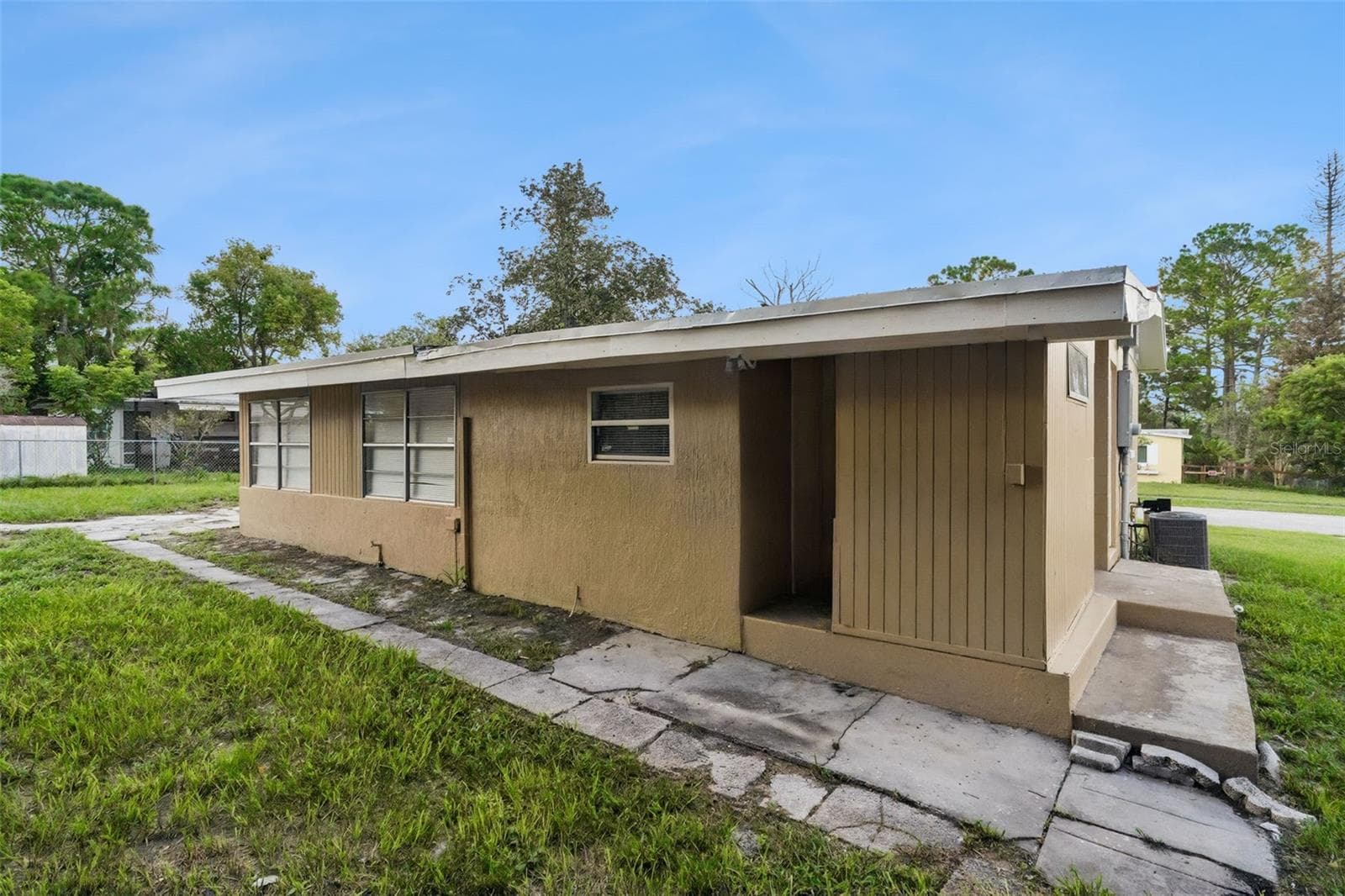 Back Exterior has breezeway to storage room and laundry area - 928 VIVIAN TER, DELTONA