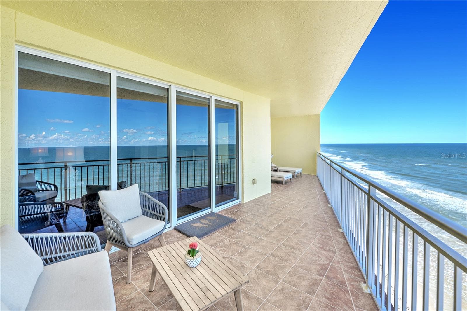 Long ocean front balcony has sliders from living room and primary suite. - 1900 N ATLANTIC AVE #1603, DAYTONA BEACH