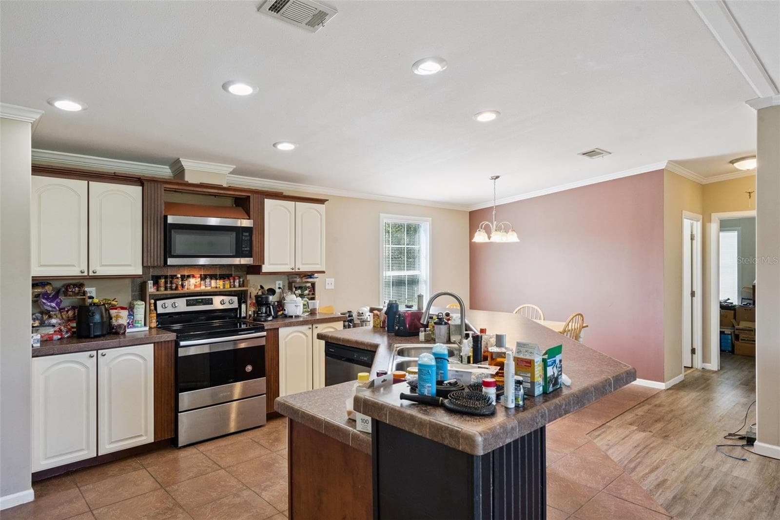 Kitchen features White Cabinetry accented with crown molding and stainless steel appliance package - 2478 BUCK BOARD TRL, LAKE WALES