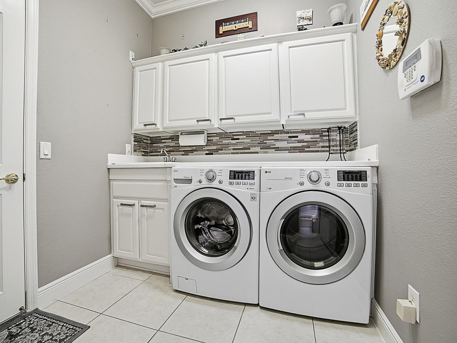 EXPANDED LAUNDRY ROOM OFFERS THE SAME LOVELY DETAILS AS THE KITCHEN WITH FRONT LOAD WASHER AND DRYER. - 1897 HARTFORD PATH, THE VILLAGES