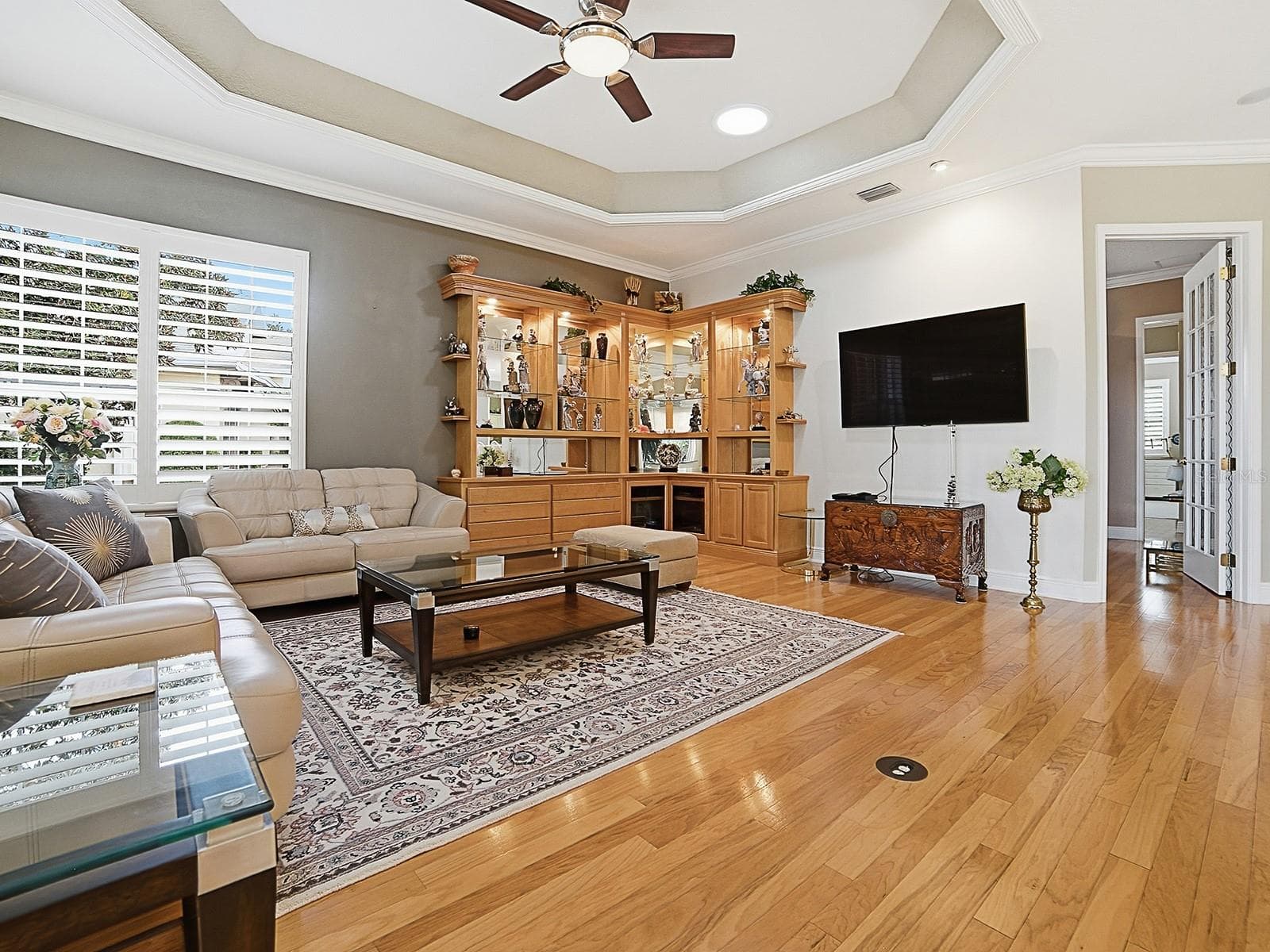 LOVELY LIVING ROOM WITH TRAY CEILING WITH CROWN TRIM, AND 2 MORE SOLAR TUBES. THERE IS CROWN MOLDING AND PLANTATION SHUTTERS THROUGHOUT THE HOME. - 1897 HARTFORD PATH, THE VILLAGES
