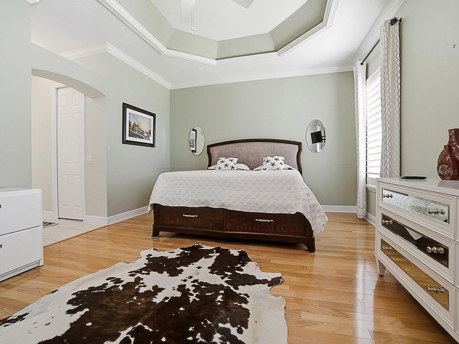 PRIMARY BEDROOM WITH TRAY CEILING, CROWN MOLDING, AND THOSE BEAUTIFUL HARDWOOD FLOORS. - 1897 HARTFORD PATH, THE VILLAGES