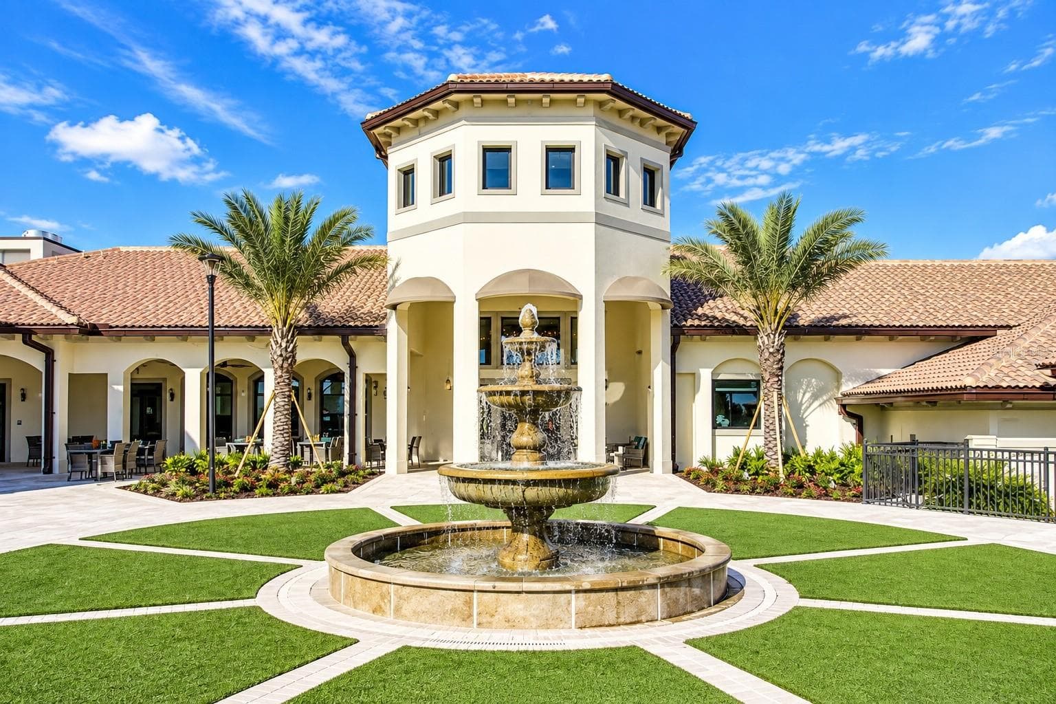 Elegant ChampionsGate clubhouse entrance featuring Mediterranean-inspired architecture, tropical landscaping and a central fountain. - 1516 BUNKER DR, DAVENPORT