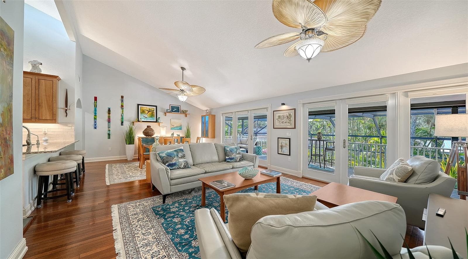Spacious living room filled with natural light and opening to the covered balcony. - SARASOTA
