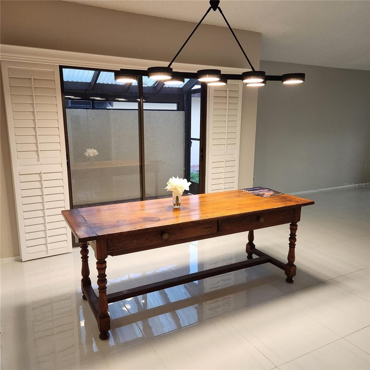Formal dining area has a beautiful light and room for a large table to seat 8. The sliders to the enclosed outdoor sitting area have Plantation shutters so you can have a classy formal dining area. - 49 SANDSTONE CIR, VENICE
