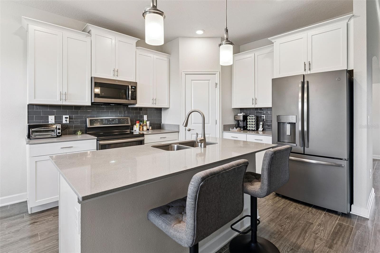 Timeless white shaker cabinetry accented with crown molding and brushed-nickel hardware - 4075 BEDFORD AVE, WINTER HAVEN